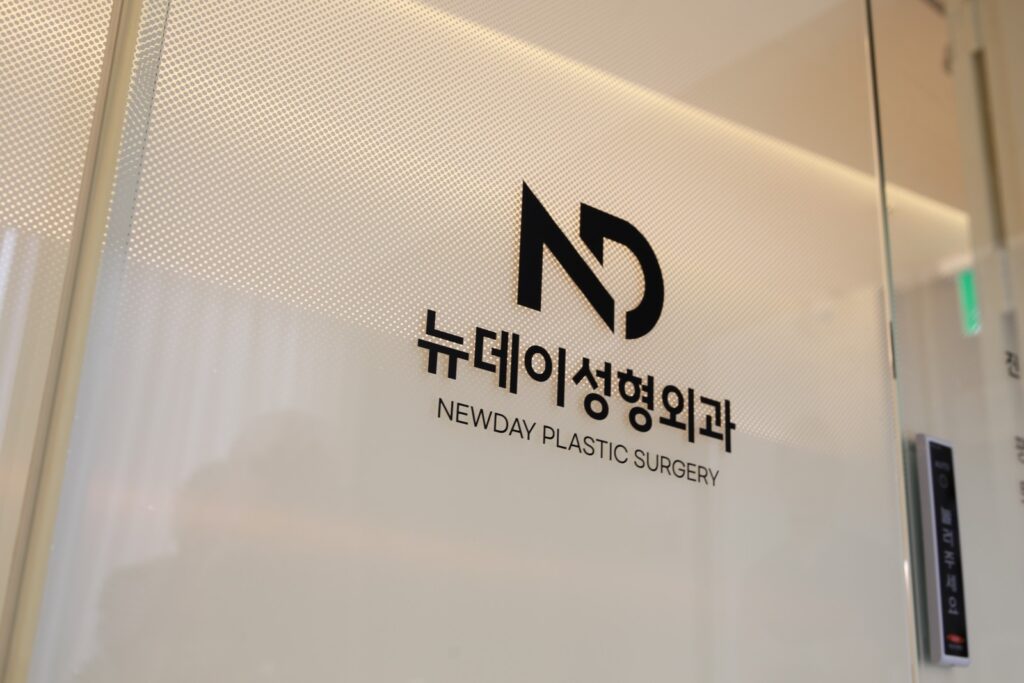 논현역 뉴데이성형외과 입구 유리벽에 새겨진 ND 로고와 영문 상호