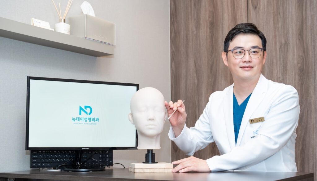 논현역 뉴데이성형외과 원장이 두상 모형과 모니터 앞에서 설명하는 모습